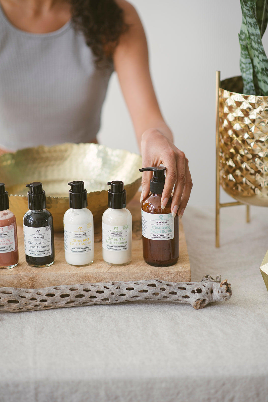 Woman displaying all-natural facial cleansers by Nezza Naturals